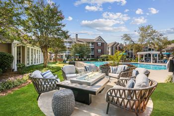 A backyard with a pool and patio furniture.